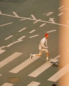 a man riding a skateboard down the middle of a street next to a cross walk