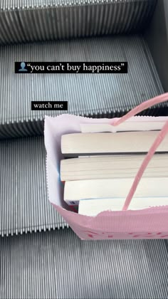 an escalator with some books in it and a sign that says you can't buy happiness watch me