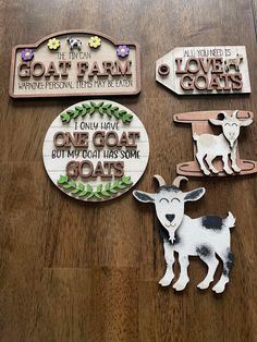 three wooden signs with animals on them sitting on a table next to some magnets that say, i only have one goat but not has some goats