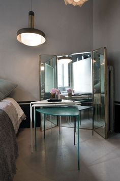 a bedroom with a table and mirror in it