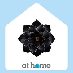 a black flower on top of a white house with the words at home above it