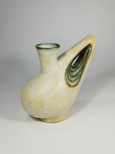 a white and green vase sitting on top of a table