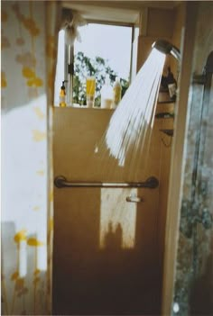 the shower head is spraying water from it's faucet in front of a window