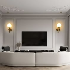 a living room with two white couches and a flat screen tv on the wall