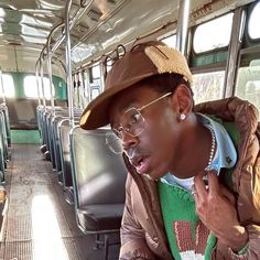 a man wearing glasses and a hat on a bus