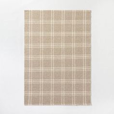 a beige and white plaid rug on a white background