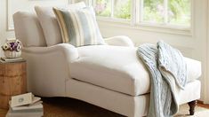 a white chair sitting next to a window in a living room