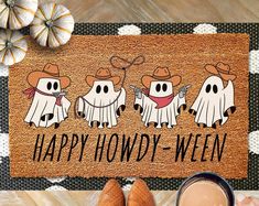 a door mat that says happy hod - ween with three ghost characters on it