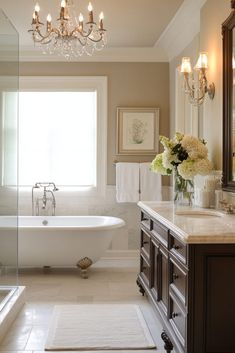 a bathroom with a tub, sink and chandelier hanging from it's ceiling