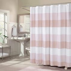 a pink and white shower curtain in a bathroom