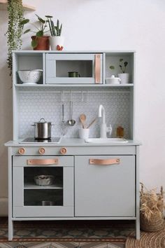 a kitchen with white cabinets and pink accents