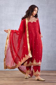 Editor's Note Featuring a bright red golden thread embroidered bandgala kurta set in raw silk along with sheer dupatta in silk organza Color: Red Fabric: Raw silk, cotton voile, silk organza Components: Kurta, dupatta and pant Embroidery details: Hand embroidery, dori and hand adda work Fit: Relaxed Occasion: Festive Care: Dry Clean Only About the Designer Torani by Karan Torani stands handcrafted luxury inspired by the myriad tales of Indian mythology. Torani is a potpourri of all things nostal Batik Fashion, Embroidery Suits Design, Straight Kurta, Boutique Dress Designs, Pattern Embroidery, Organza Dupatta, Kurta With Pants, Embroidery Suits, Silk Embroidery