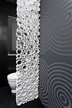 the toilet is next to a wall with circles on it