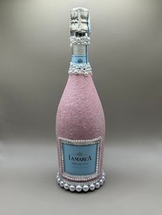 a bottle of pink wine with pearls on the bottom and a label that says lamarca