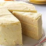 a white cake sitting on top of a table next to plates and utensils