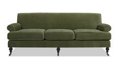 a green couch sitting on top of a white floor