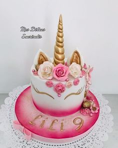 a birthday cake decorated with flowers and a unicorn's horn