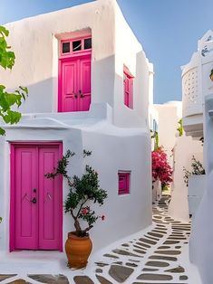 a white building with pink doors and windows