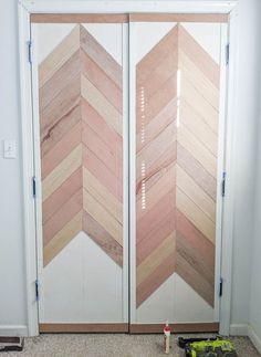 two wooden doors with different colored chevrons painted on the front and back sides