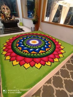 a colorful flower design is on the ground in front of a large mirror and window