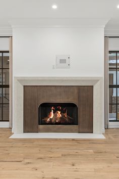 an empty living room with a fireplace and sliding glass doors