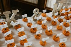 small pumpkins are arranged on a table with name tags and place cards for each individual