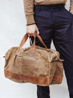 Say hello to your new getaway go-to! This spacious weekender bag is hand-crafted with durable canvas and genuine leather – that means it’s made to last, whether it’s a long weekend away or a two week trip to Paris (even with baggage handling!) And say goodbye to shoulder aches once and for all, no matter how long that airport line is — an adjustable strap configuration offers multiple ways to carry this bag. Throw it over your shoulder with the adjustable shoulder strap, grab the top carry handl Brown Weekender Bag With Luggage Sleeve For Everyday Use, Casual Brown Weekender Bag For Weekend Trips, Cotton Duffle Bag With Luggage Sleeve For Overnight Trips, Brown Cotton Travel Bag With Large Capacity, Canvas Shoulder Bag For Overnight Trips, Rectangular Waxed Canvas Weekender Bag With Large Capacity, Cotton Travel Bag With Canvas Lining For Overnight Trips, Everyday Waxed Canvas Rectangular Duffle Bag, Everyday Rectangular Waxed Canvas Duffle Bag