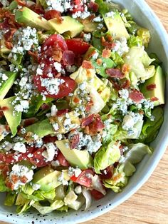 a salad with lettuce, tomatoes, avocado and other toppings