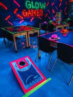 a room filled with tables and chairs covered in neon colored games on top of them