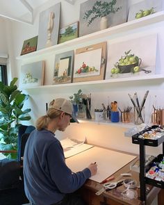 a woman sitting at a desk writing on a piece of paper in her home office