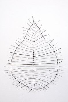 a wire sculpture is hanging on the wall