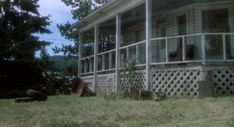 an old house sitting on the side of a hill with trees in the back ground