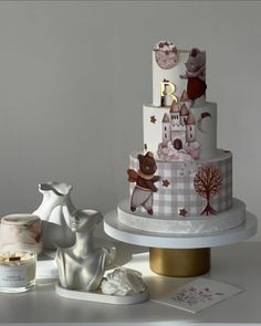 a three tiered cake sitting on top of a white table next to other items