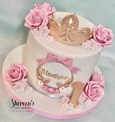 a white cake with pink flowers and butterflies on top