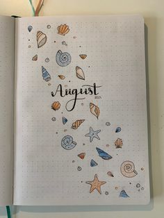 an open notebook with the word august written on it and various sea creatures around it