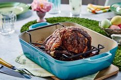 a roasting pan filled with meat on top of a table next to other food items