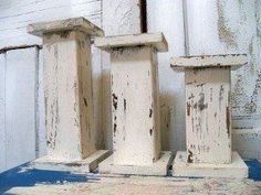 three old white wooden pillars sitting next to each other on a blue and white table