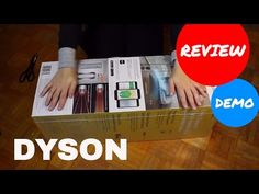 the box is open and it has hands in it, with an ad for dyson