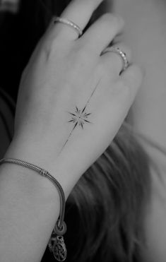 a woman's arm with a small star tattoo on the left side of her wrist