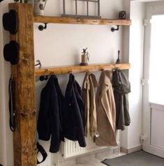 the coat rack is made from an old wooden beam and holds several coats on it