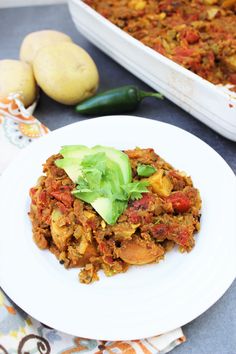 a white plate topped with food next to a casserole dish