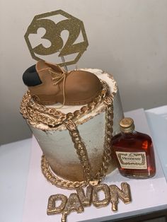 a cake that has some type of shoe on it with a bottle of booze next to it