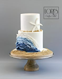 a three tiered cake with blue and white icing