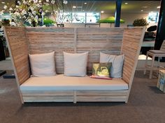 a couch made out of wooden slats and pillows on display at a furniture store