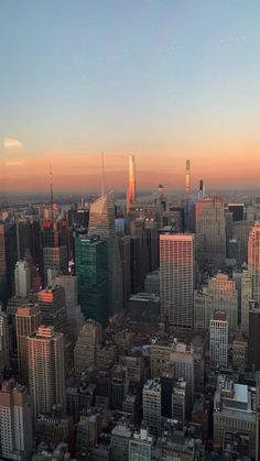 an aerial view of the city skyline at sunset or dawn with skyscrapers and other tall buildings