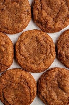 several cookies sitting on top of a white paper covered tray with one cookie in the middle