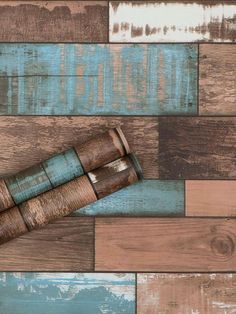 a wooden floor with several different colored wood planks on it and a rolled up piece of paper in the middle