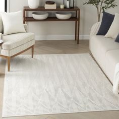 a living room filled with furniture and a white rug