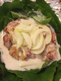 lettuce wrapped in foil with meat and onions on top, ready to be eaten