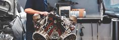 a man working on an engine in a garage